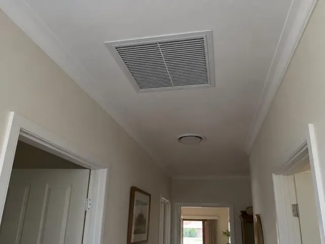 Ceiling return-air grille in a hallway with white cornices and doorways in Cumberland Park